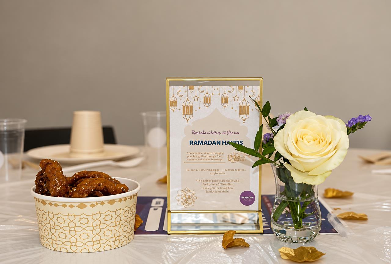 Gedekte iftartafel met Ramadan Hands-kaart, roos en zoetigheden